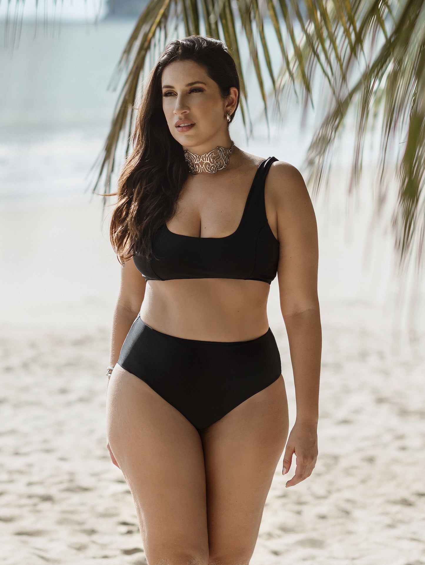 Modelo na beira-mar da praia do cabo branco em João Pessoa, vestindo biquini hot pant preta e top com decote reto.