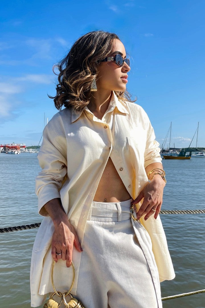 Mulher em marina de Joao Pessoa, vestindo camisa oversized de manga longa e calca pantalona de linho