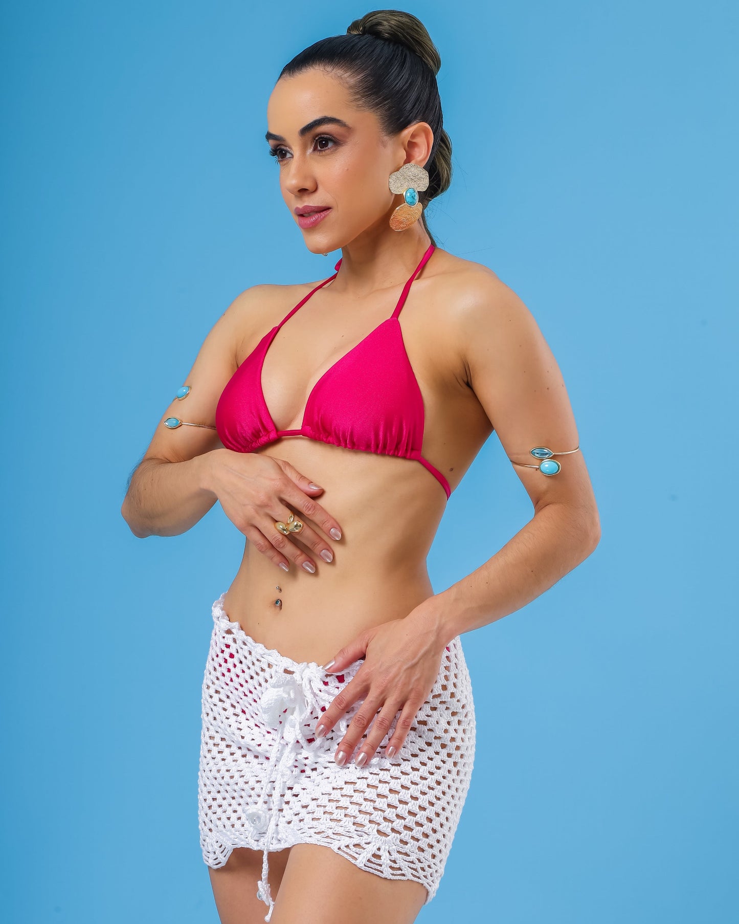 Modelo veste saia curta de croche branca e top biquini cortininha rosa pink.