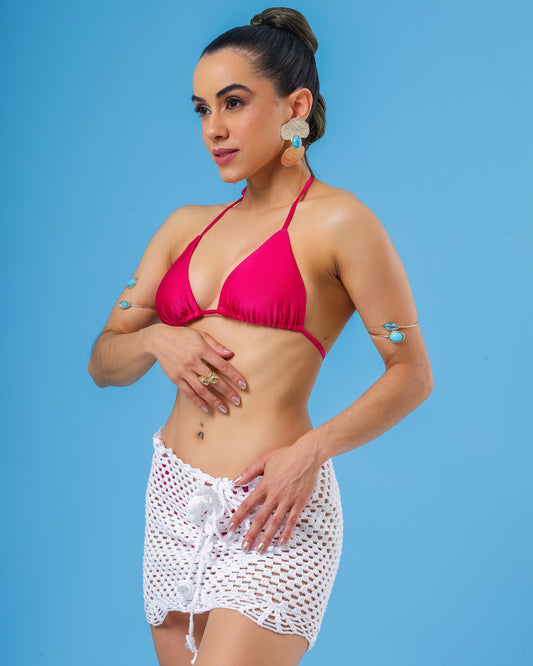 Modelo veste saia curta de croche branca e top biquini cortininha rosa pink.